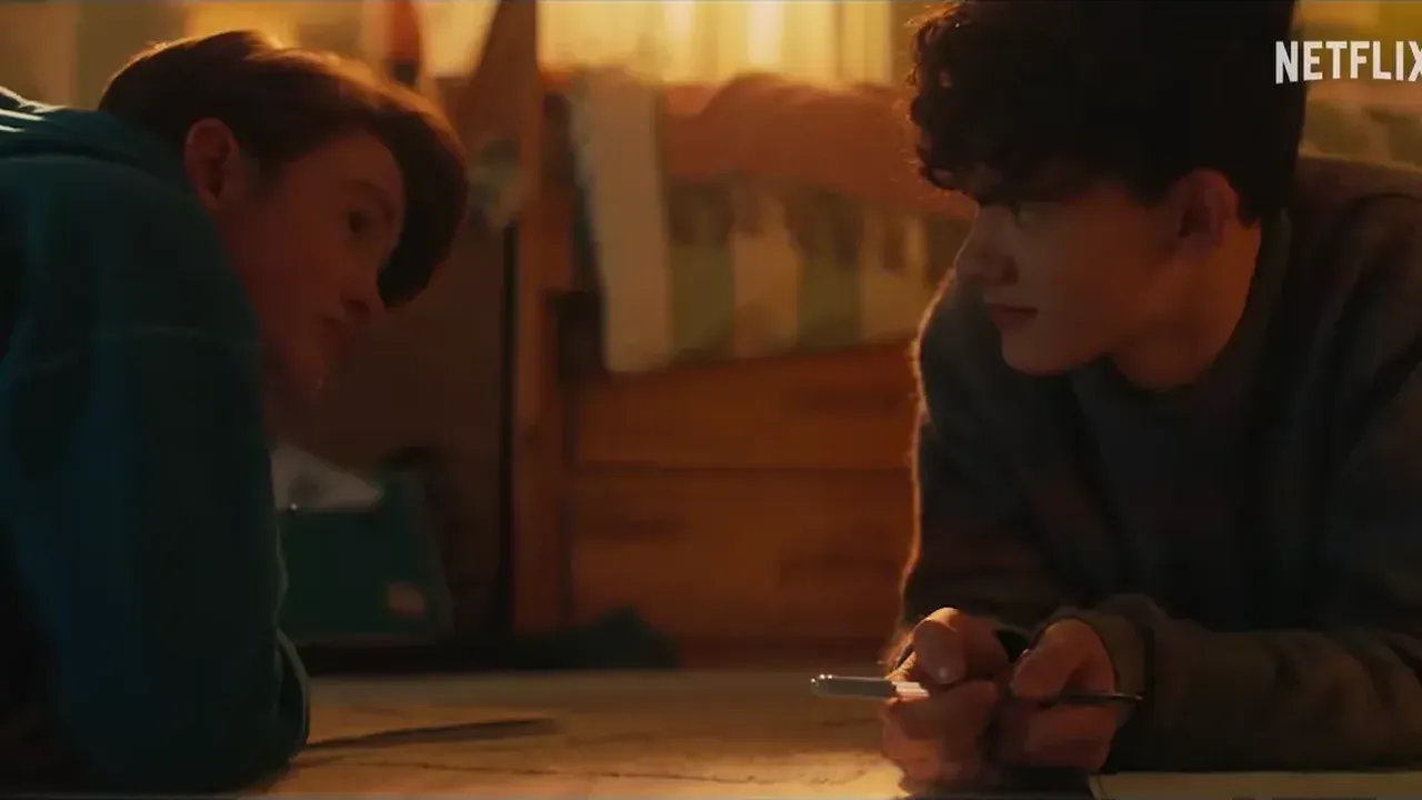 Dos chicos tumbados en el suelo de una habitación, en un fotograma del tráiler de Heartstopper para siempre